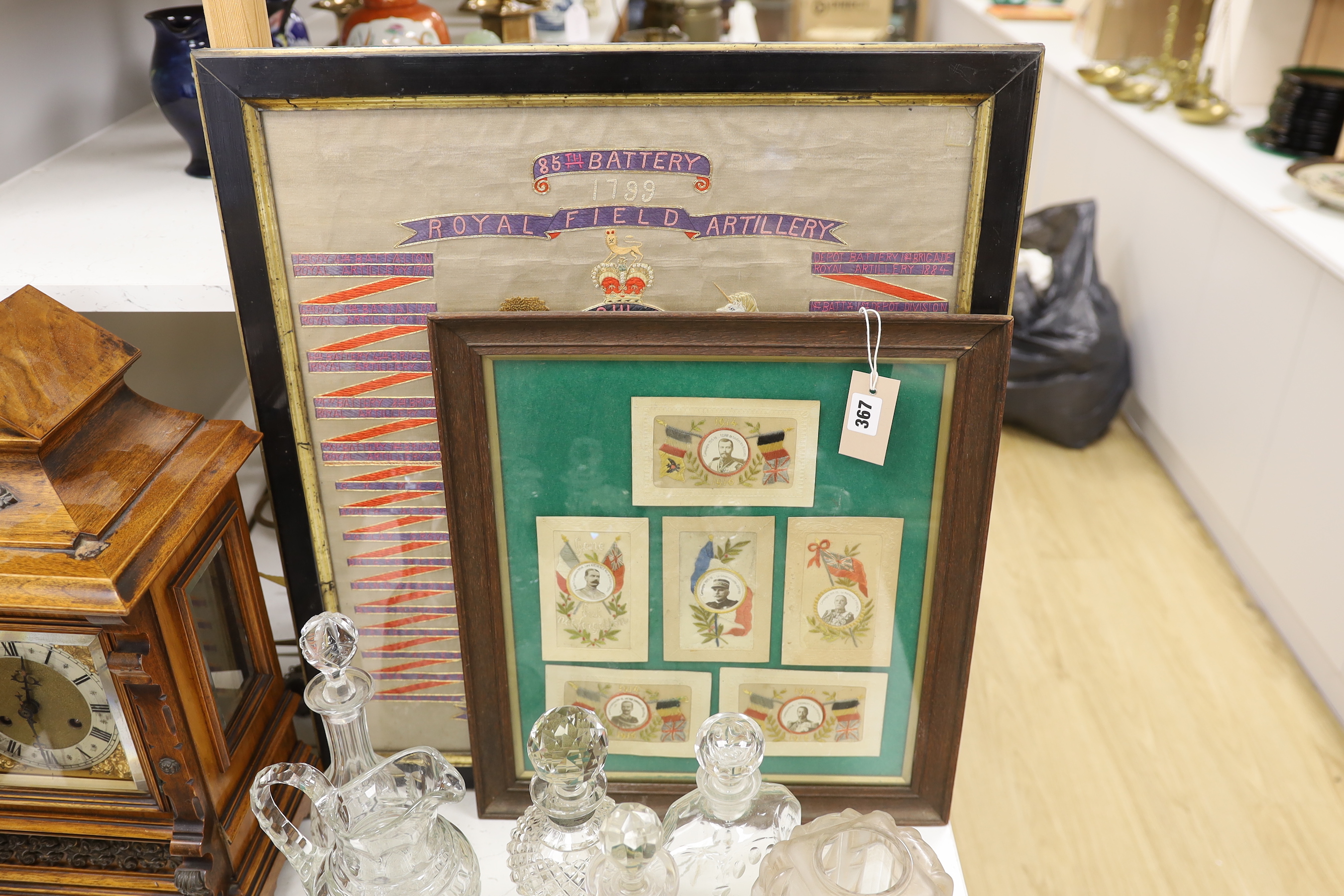 A framed Royal Field Artillery crest and six WWI postcards, framed